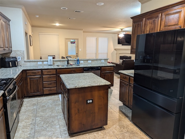 kitchen with light stone counters, a center island, sink, kitchen peninsula, and stainless steel appliances