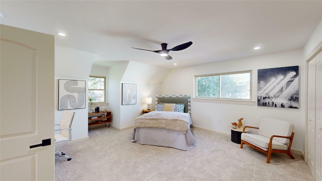 carpeted bedroom with ceiling fan, a closet, vaulted ceiling, and multiple windows