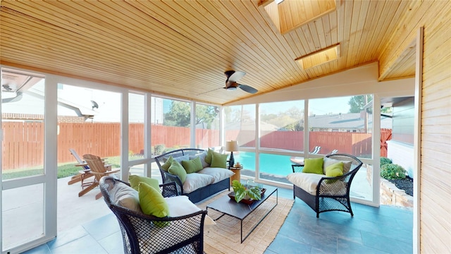 sunroom with ceiling fan, vaulted ceiling with skylight, and wooden ceiling