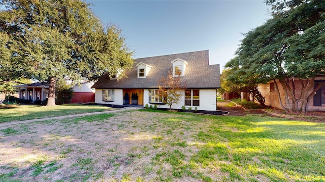 cape cod-style house featuring a front lawn