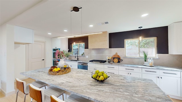 kitchen featuring recessed lighting, light wood-type flooring, beverage cooler, and light stone counters