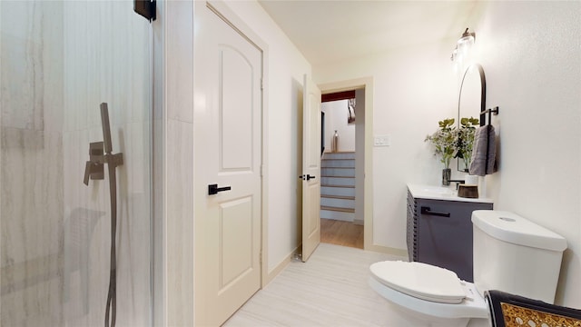 bathroom with an enclosed shower, toilet, vanity, and baseboards