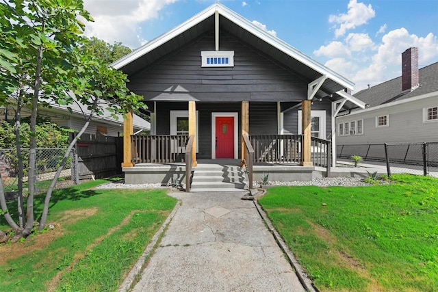 bungalow with covered porch and a front yard