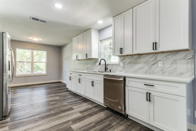 kitchen featuring decorative backsplash, white cabinetry, dark hardwood / wood-style floors, and appliances with stainless steel finishes