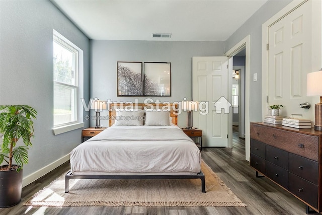 unfurnished living room featuring dark hardwood / wood-style flooring, a stone fireplace, and ceiling fan