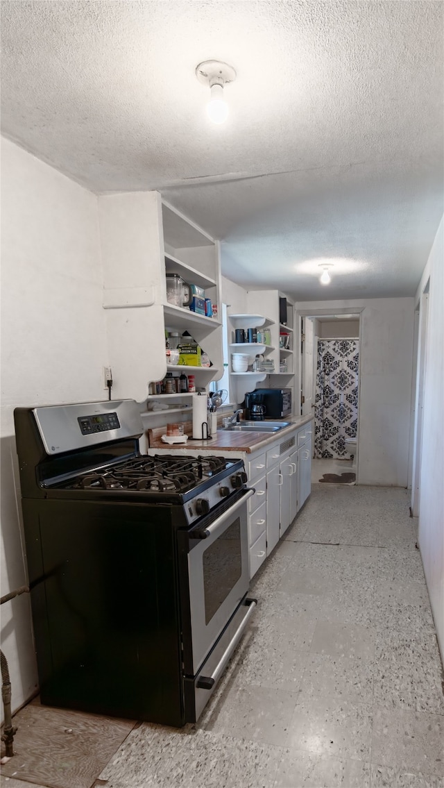 kitchen with gas range and a textured ceiling