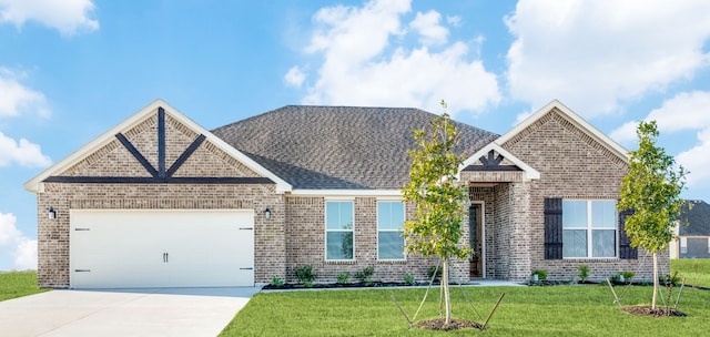 view of front facade with a garage, concrete driveway, brick siding, and a front yard