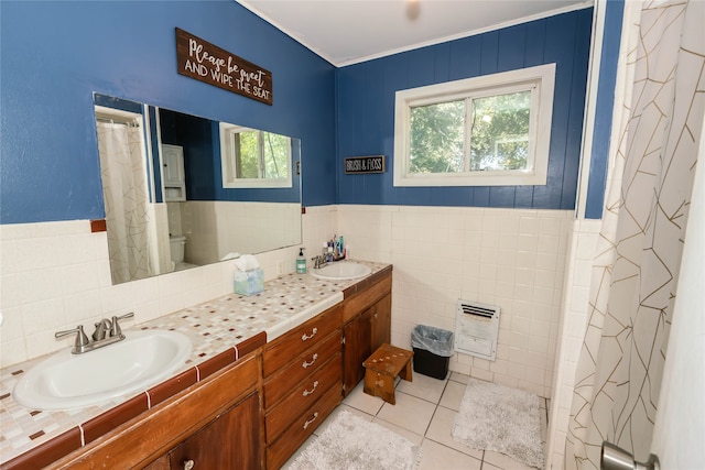 bathroom featuring heating unit, tile walls, tile patterned floors, vanity, and toilet