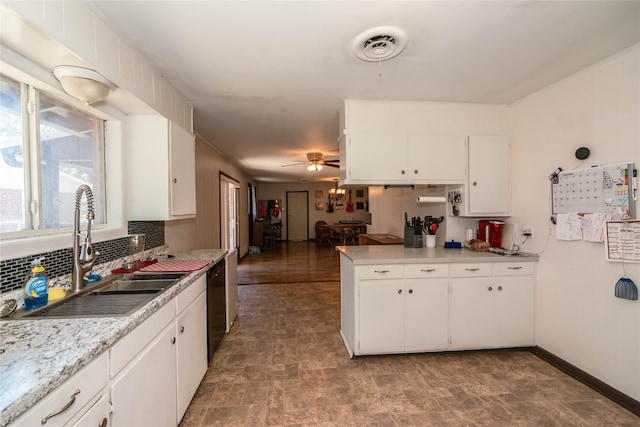 kitchen with sink, kitchen peninsula, backsplash, white cabinetry, and black dishwasher