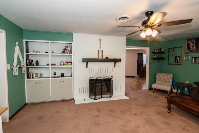 living room with ceiling fan, light colored carpet, and a fireplace