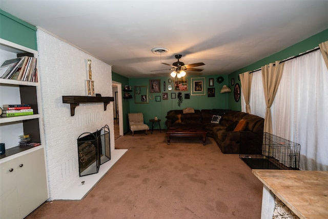 carpeted living room with ceiling fan and a fireplace