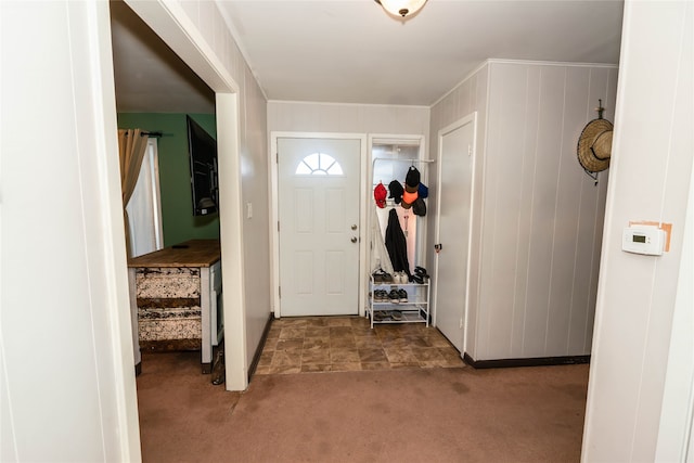 entryway featuring dark carpet and crown molding