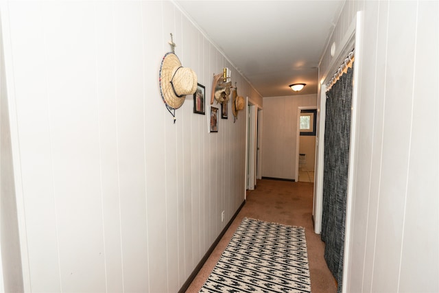 corridor with light colored carpet and wood walls