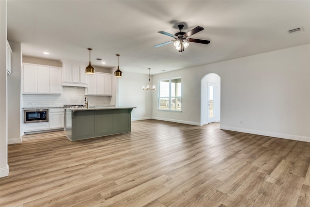 11708 Blackfoot Ct, Godley, TX 76044 - kitchen featuring visible vents, open floor plan, light wood-type flooring, white cabinets, and backsplash