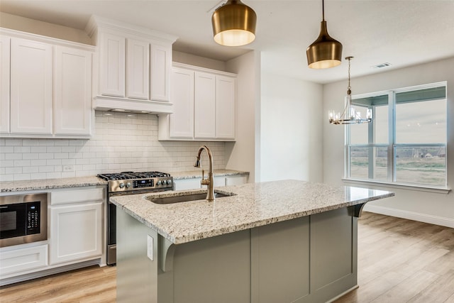11708 Blackfoot Ct, Godley, TX 76044 - kitchen with a sink, stainless steel range with gas stovetop, light wood-style flooring, built in microwave, and decorative backsplash