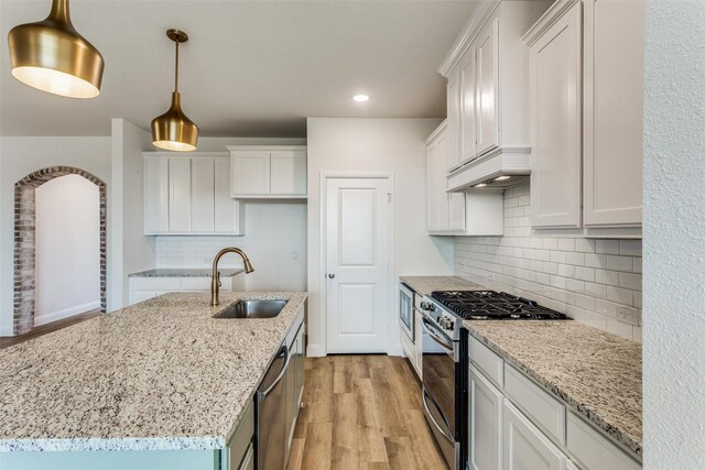 11708 Blackfoot Ct, Godley, TX 76044 - kitchen featuring recessed lighting, white cabinets, a sink, light wood finished floors, and stainless steel appliances