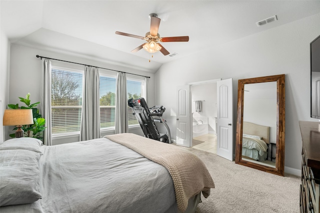 bedroom with lofted ceiling, ceiling fan, light colored carpet, and ensuite bath