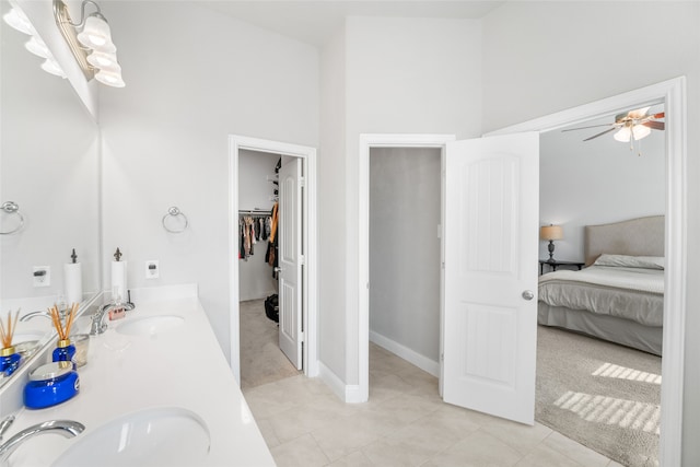 bathroom featuring a towering ceiling, tile patterned flooring, ceiling fan, and vanity