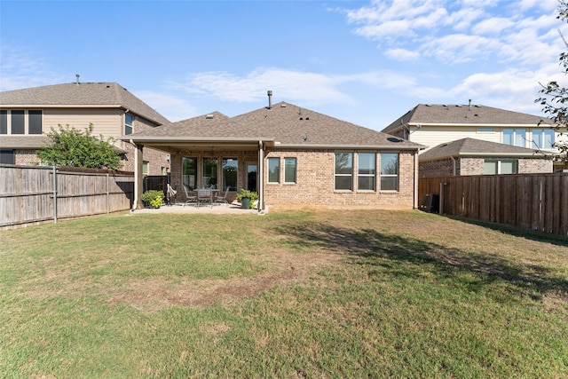 rear view of property featuring a lawn and a patio area