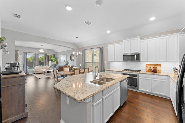 kitchen with white cabinetry, stainless steel appliances, lofted ceiling, a center island with sink, and sink