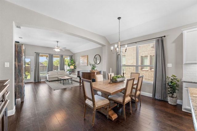 dining space featuring ceiling fan with notable chandelier, lofted ceiling, and dark hardwood / wood-style floors