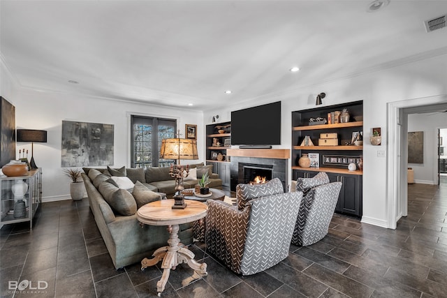 living room with a tiled fireplace, ceiling fan, crown molding, and built in features