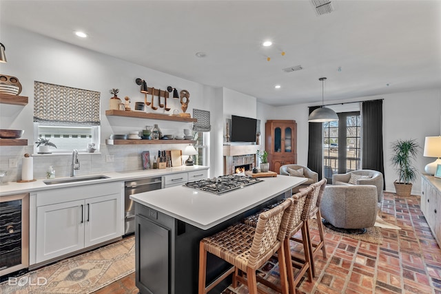 kitchen featuring beverage cooler, decorative light fixtures, plenty of natural light, and sink