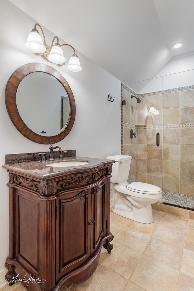 bathroom featuring vanity, lofted ceiling, a shower with shower door, tile patterned floors, and toilet