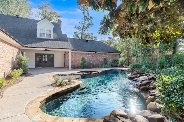 view of swimming pool with ceiling fan, french doors, and a patio area