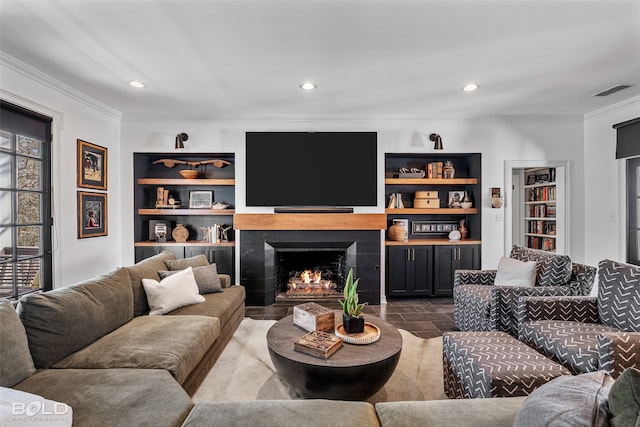 living room featuring ornamental molding and built in shelves