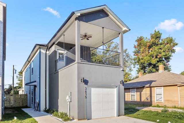 view of front of home with ceiling fan, a balcony, and a garage