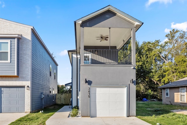 view of front of house with a balcony, a front yard, a garage, and ceiling fan