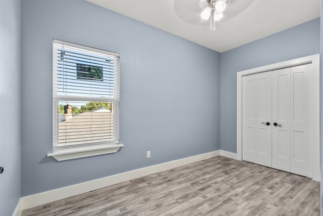 unfurnished bedroom with a closet, ceiling fan, and light hardwood / wood-style flooring