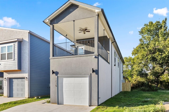 view of side of home featuring a garage, a balcony, ceiling fan, and a lawn