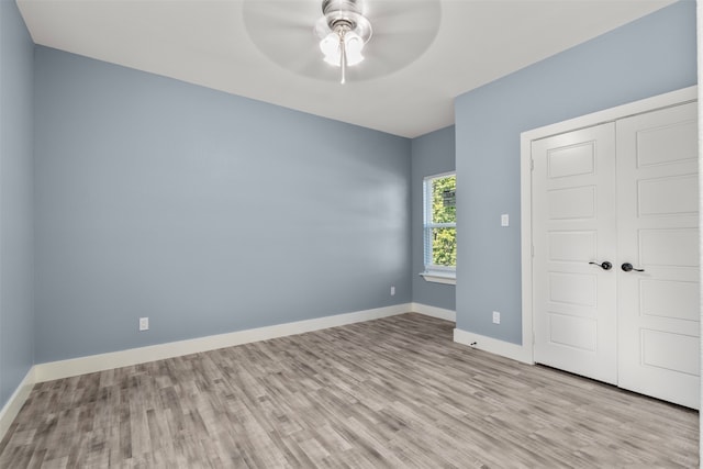 unfurnished bedroom featuring light hardwood / wood-style flooring, a closet, and ceiling fan