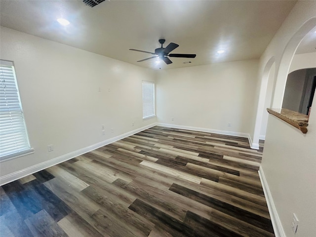 unfurnished room featuring dark hardwood / wood-style flooring, ceiling fan, and a wealth of natural light