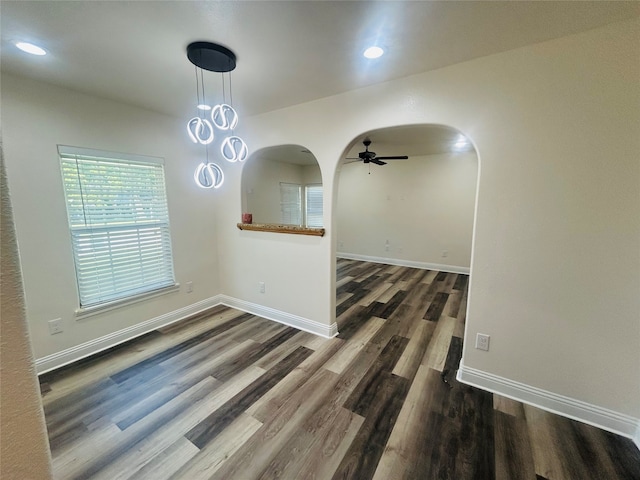 unfurnished dining area with ceiling fan and dark wood-type flooring