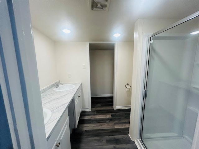 bathroom featuring walk in shower, vanity, and hardwood / wood-style floors