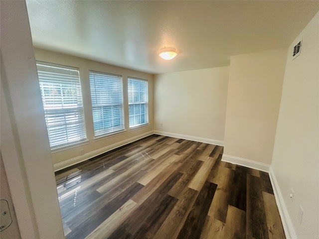 empty room with dark hardwood / wood-style flooring