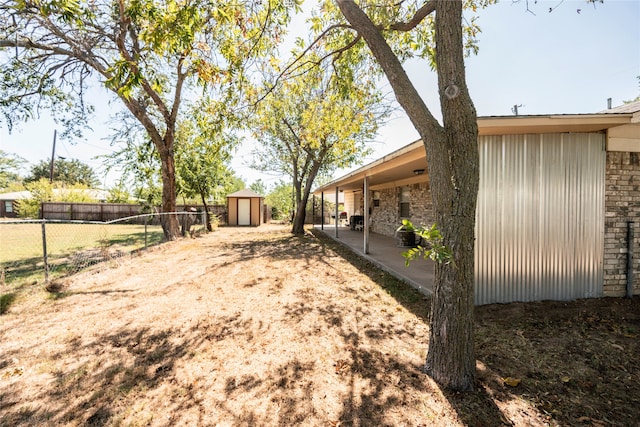 view of yard featuring a patio and a storage shed