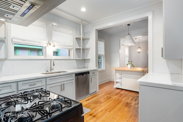 kitchen with light hardwood / wood-style floors, tasteful backsplash, stove, stainless steel dishwasher, and sink