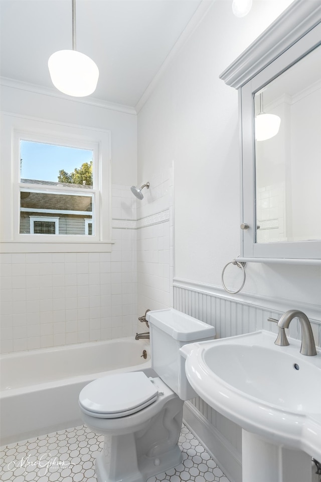 full bathroom featuring crown molding, tile patterned flooring, tiled shower / bath combo, and toilet