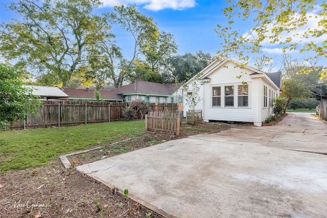 rear view of property featuring a patio and a yard