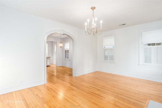 empty room featuring light hardwood / wood-style flooring, crown molding, and a healthy amount of sunlight