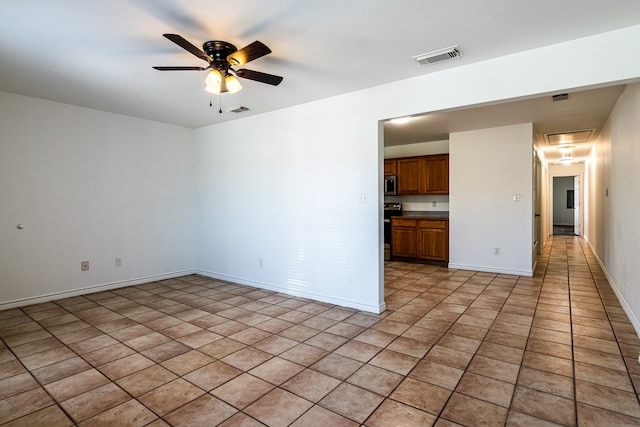 tiled empty room featuring ceiling fan