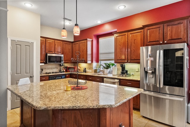 kitchen featuring light stone countertops, light tile patterned floors, appliances with stainless steel finishes, and a kitchen island