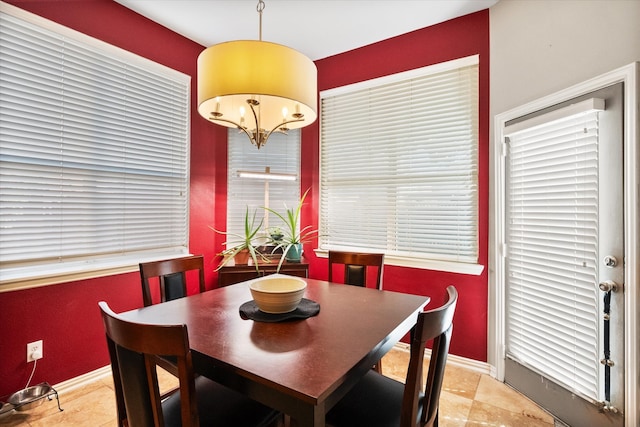 dining area featuring light tile patterned floors and a notable chandelier