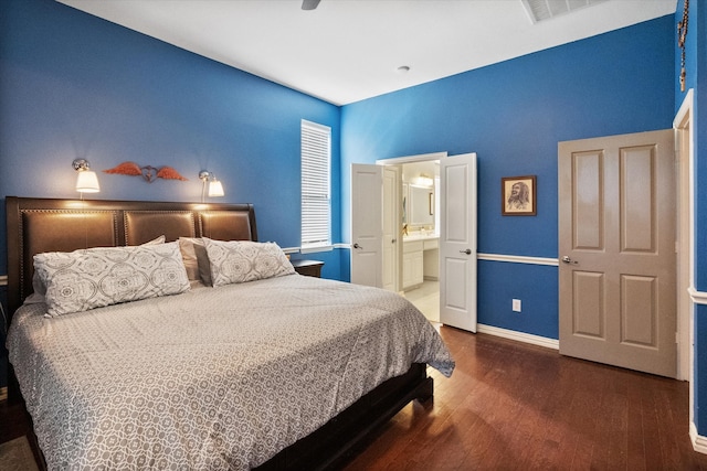 bedroom featuring ceiling fan, ensuite bathroom, and dark hardwood / wood-style flooring