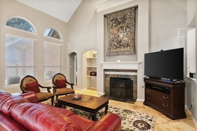 living room featuring built in shelves, light tile patterned flooring, high vaulted ceiling, and a tile fireplace