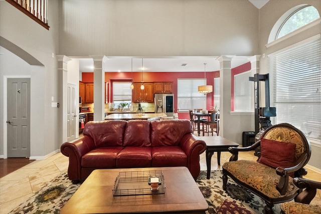 living room with decorative columns and a high ceiling